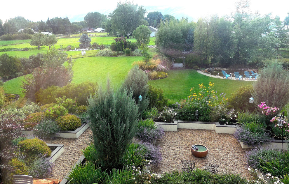 Ejemplo de jardín tradicional grande en verano en patio trasero con jardín francés y exposición total al sol