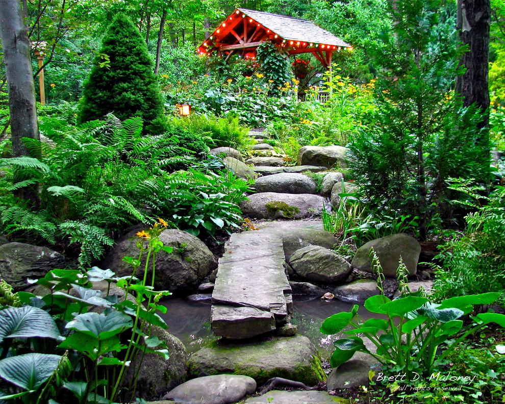 Großer, Halbschattiger Rustikaler Garten im Sommer, hinter dem Haus mit Wasserspiel und Natursteinplatten in Sonstige