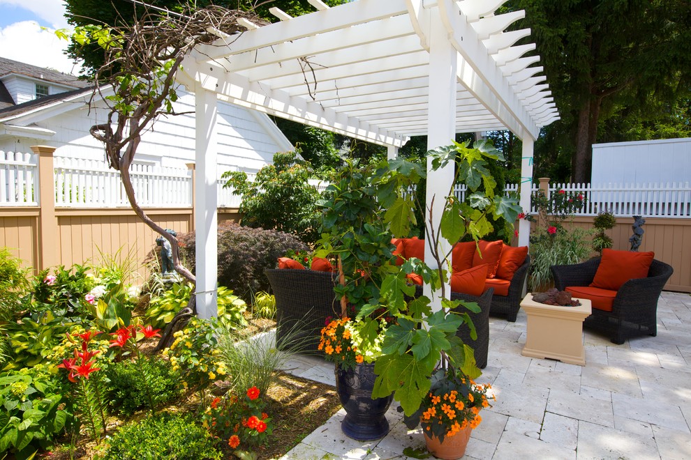 Immagine di un piccolo giardino mediterraneo dietro casa in estate con un giardino in vaso e pavimentazioni in pietra naturale