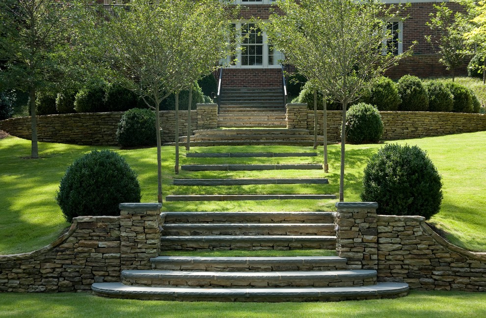 Aménagement d'un jardin classique avec une pente, une colline ou un talus et des pavés en pierre naturelle.