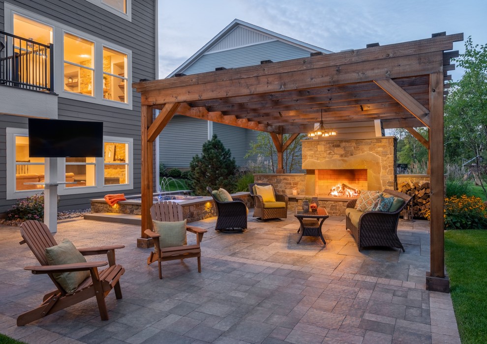 Inspiration for a large back patio in Minneapolis with a fireplace and natural stone paving.