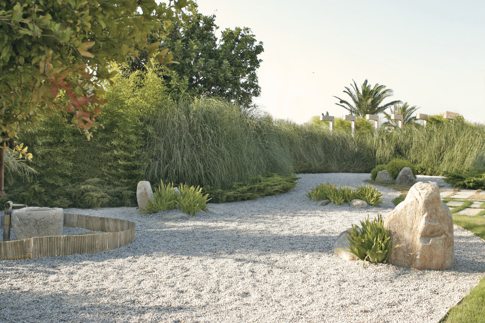 На фото: участок и сад на заднем дворе в средиземноморском стиле с покрытием из гравия с
