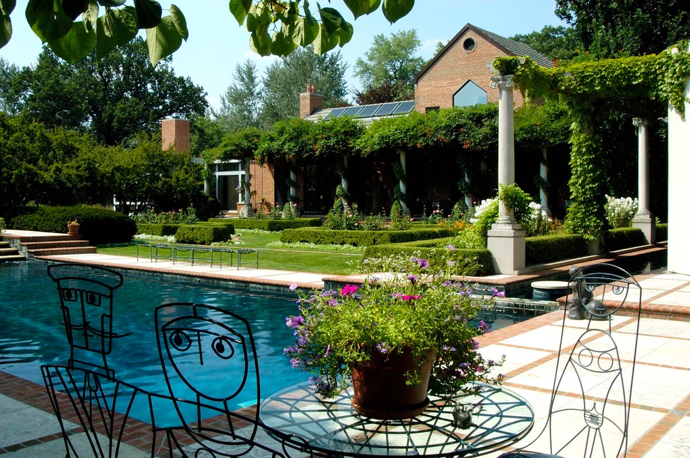 Idee per un giardino formale classico esposto in pieno sole dietro casa in estate con pavimentazioni in pietra naturale
