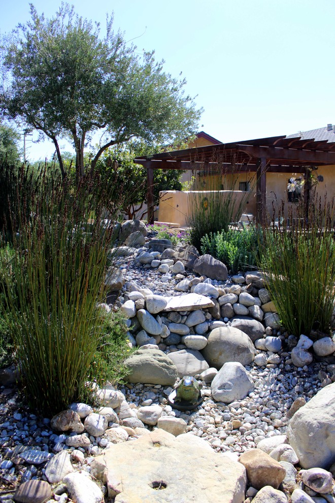 This is an example of a mediterranean backyard water fountain landscape in San Luis Obispo.