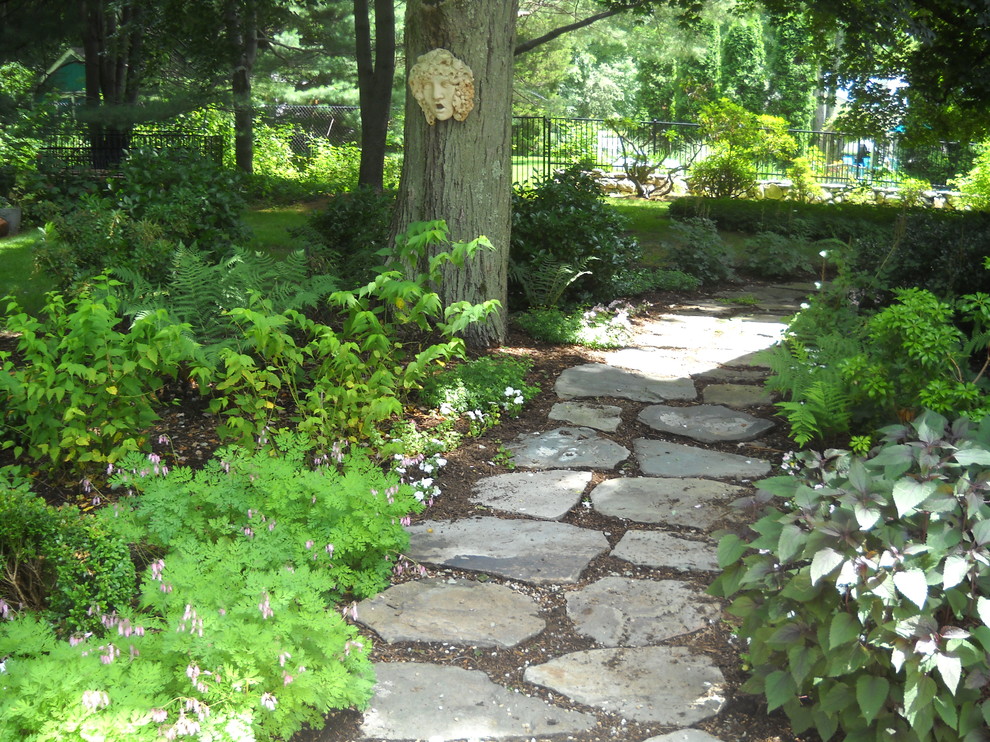 Aménagement d'un aménagement d'entrée ou allée de jardin arrière montagne au printemps avec une exposition ombragée et des pavés en pierre naturelle.