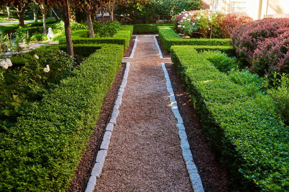Idéer för en klassisk formell trädgård framför huset på sommaren, med en trädgårdsgång och grus
