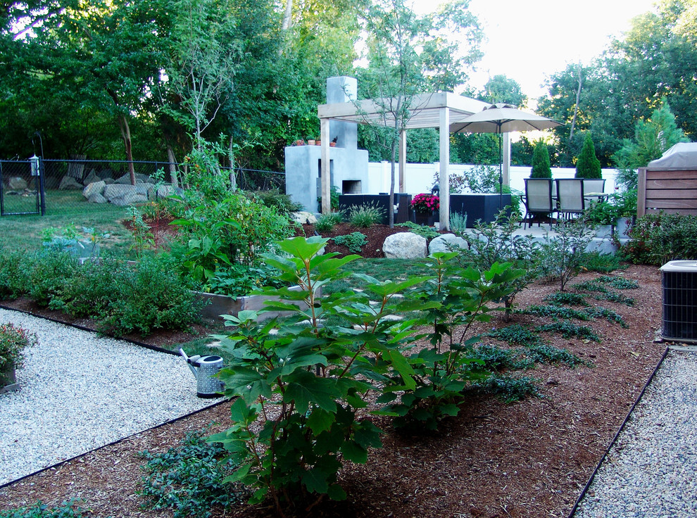 Immagine di un giardino contemporaneo esposto a mezz'ombra di medie dimensioni e dietro casa in estate con un focolare e ghiaia