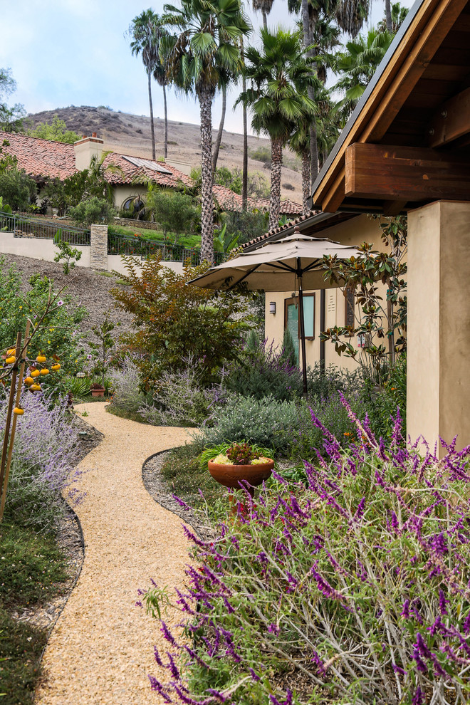 Inspiration for a mediterranean side garden in Orange County with gravel.