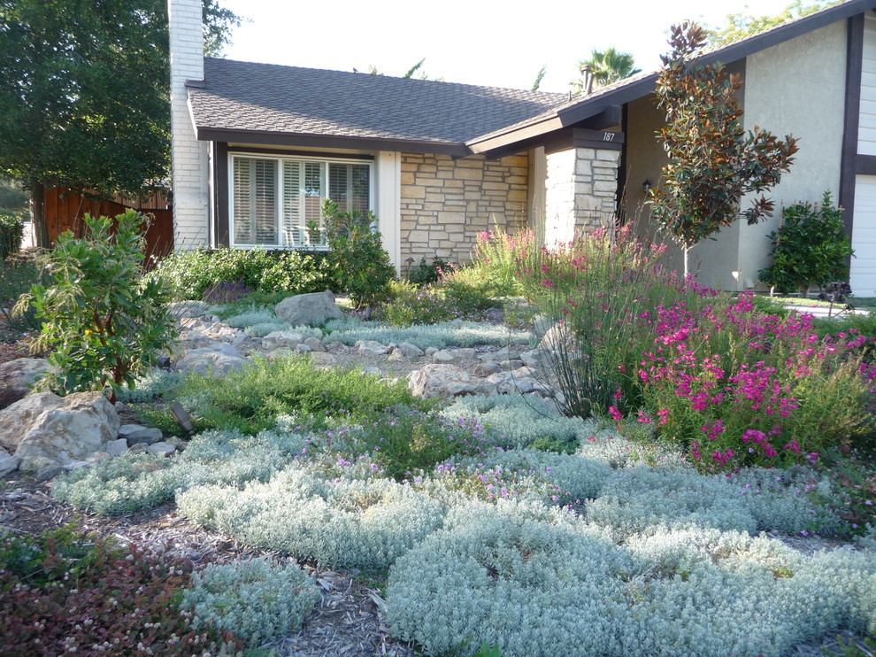 Inspiration för en mellanstor vintage trädgård i full sol som tål torka och framför huset, med naturstensplattor