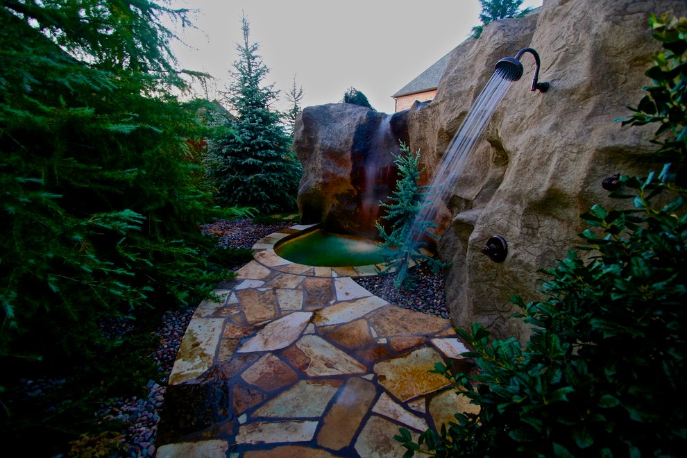Ejemplo de jardín clásico de tamaño medio en patio trasero con fuente, exposición parcial al sol y adoquines de piedra natural
