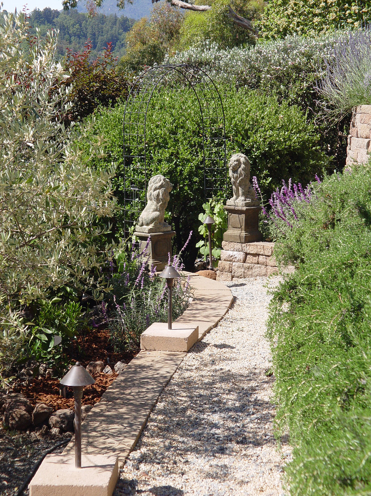 На фото: большой участок и сад на заднем дворе в средиземноморском стиле с покрытием из гравия с