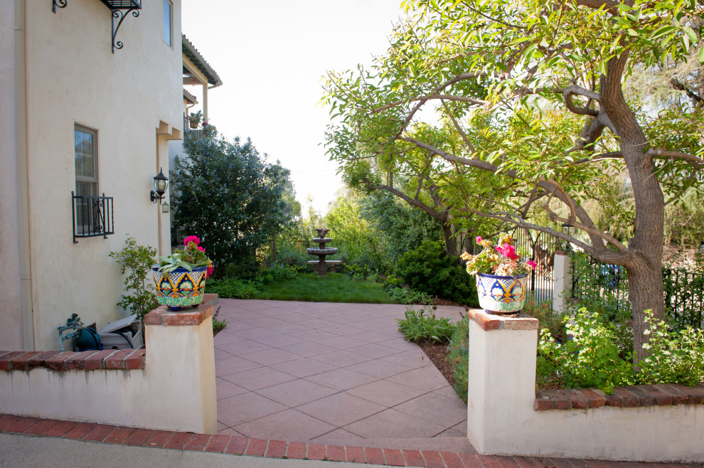 Стильный дизайн: большой весенний засухоустойчивый сад на переднем дворе в средиземноморском стиле с садовой дорожкой или калиткой, полуденной тенью и мощением тротуарной плиткой - последний тренд