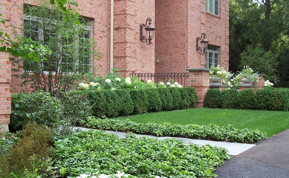 Mittelgroßer, Geometrischer Klassischer Vorgarten im Frühling mit direkter Sonneneinstrahlung und Natursteinplatten in Chicago
