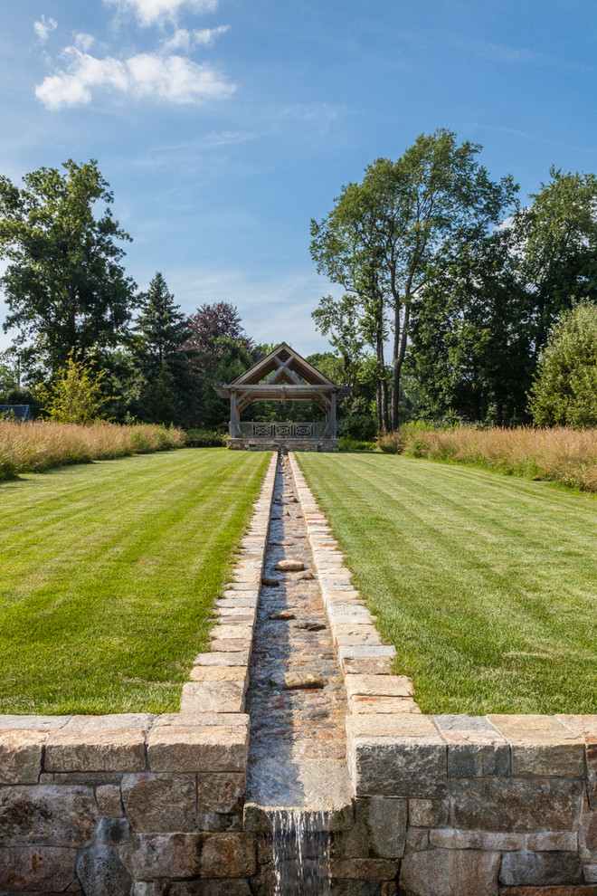 Imagen de jardín de estilo de casa de campo con fuente y exposición total al sol