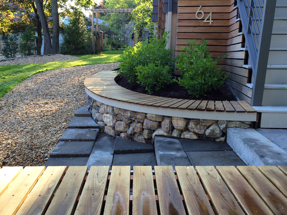 Photo of a large contemporary partial sun backyard gravel retaining wall landscape in Boston for summer.