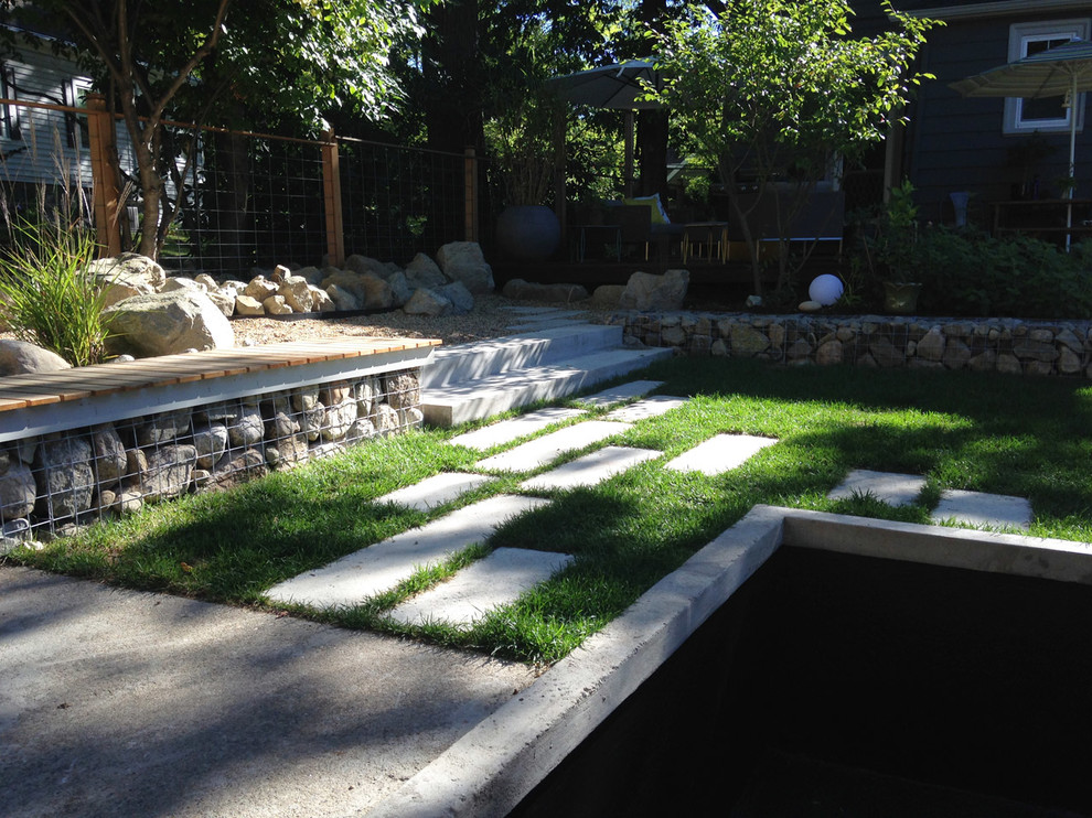 Idées déco pour un grand jardin arrière contemporain l'été avec un bassin, une exposition partiellement ombragée et des pavés en béton.