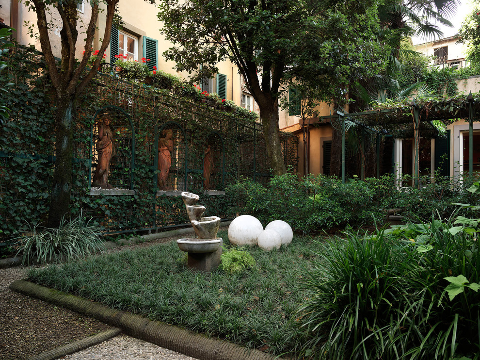 Photo of a small traditional front formal fully shaded garden for spring in Florence with natural stone paving.