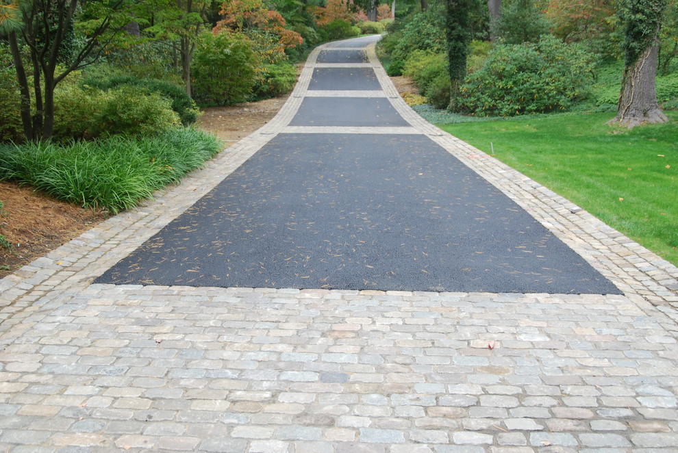 This is an example of an expansive traditional front driveway garden in New York with natural stone paving.
