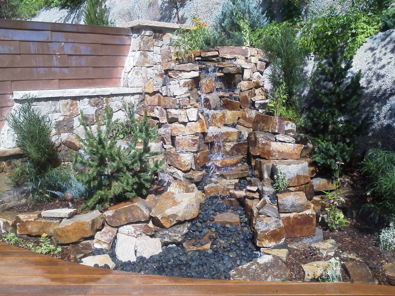 Inspiration for a mid-sized rustic full sun backyard gravel water fountain landscape in Denver for summer.