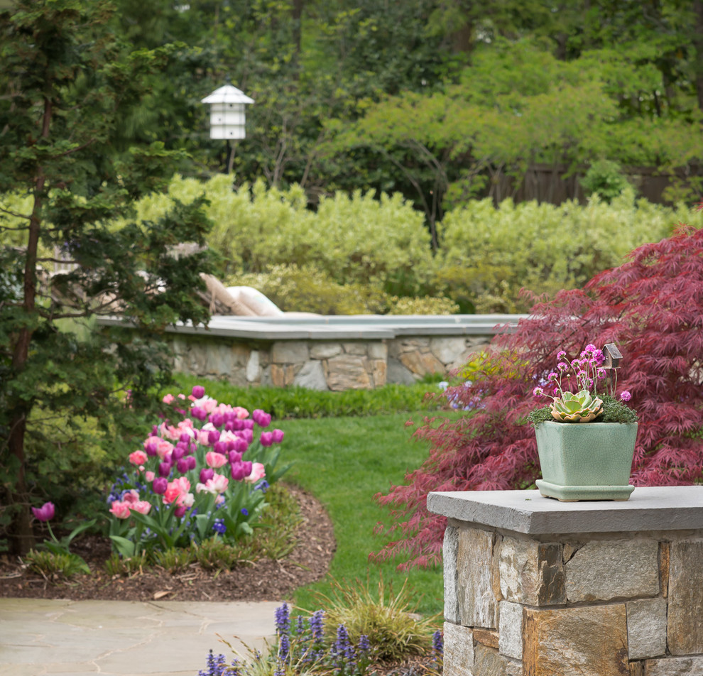 Foto di un grande giardino design esposto in pieno sole dietro casa in primavera con un giardino in vaso e pavimentazioni in pietra naturale