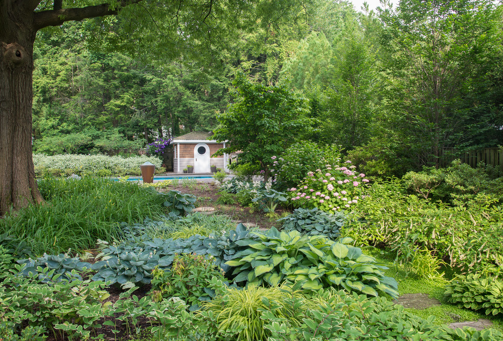 Foto di un grande giardino contemporaneo in ombra dietro casa in primavera con un ingresso o sentiero e pavimentazioni in pietra naturale