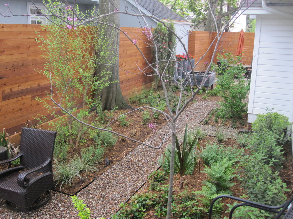 Diseño de jardín contemporáneo de tamaño medio en patio trasero con fuente, exposición parcial al sol y gravilla