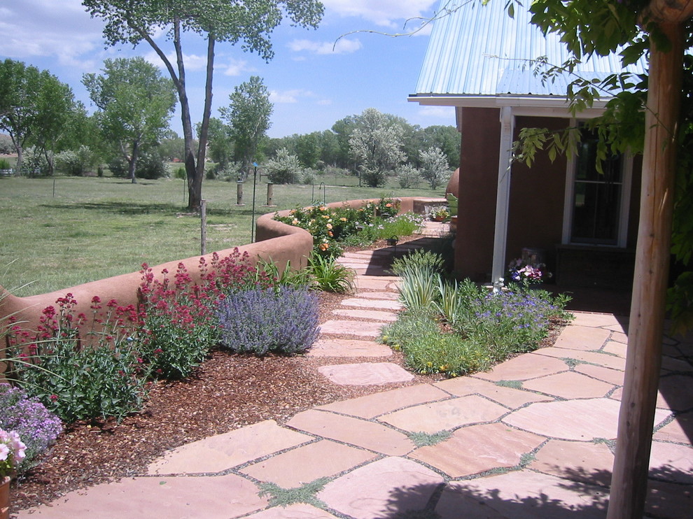 Идея дизайна: летний регулярный сад среднего размера на боковом дворе в стиле фьюжн с подпорной стенкой, полуденной тенью и покрытием из каменной брусчатки