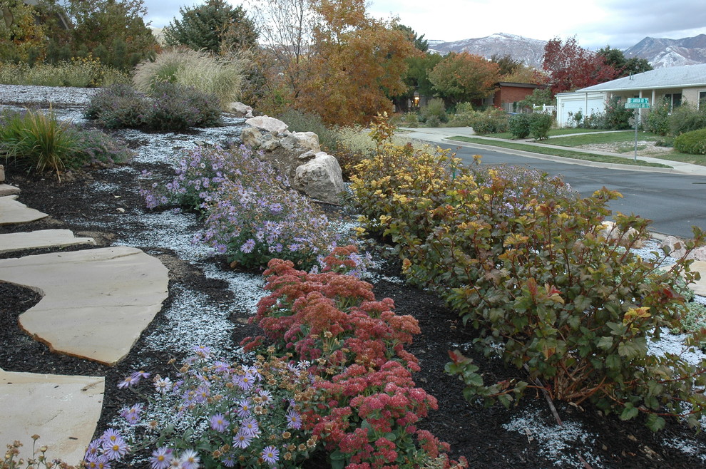 Large traditional side formal partial sun garden for autumn in Salt Lake City with natural stone paving and a garden path.