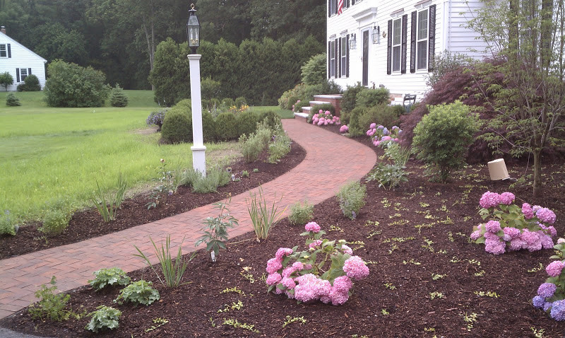 Design ideas for a mid-sized traditional front yard brick landscaping in Boston.