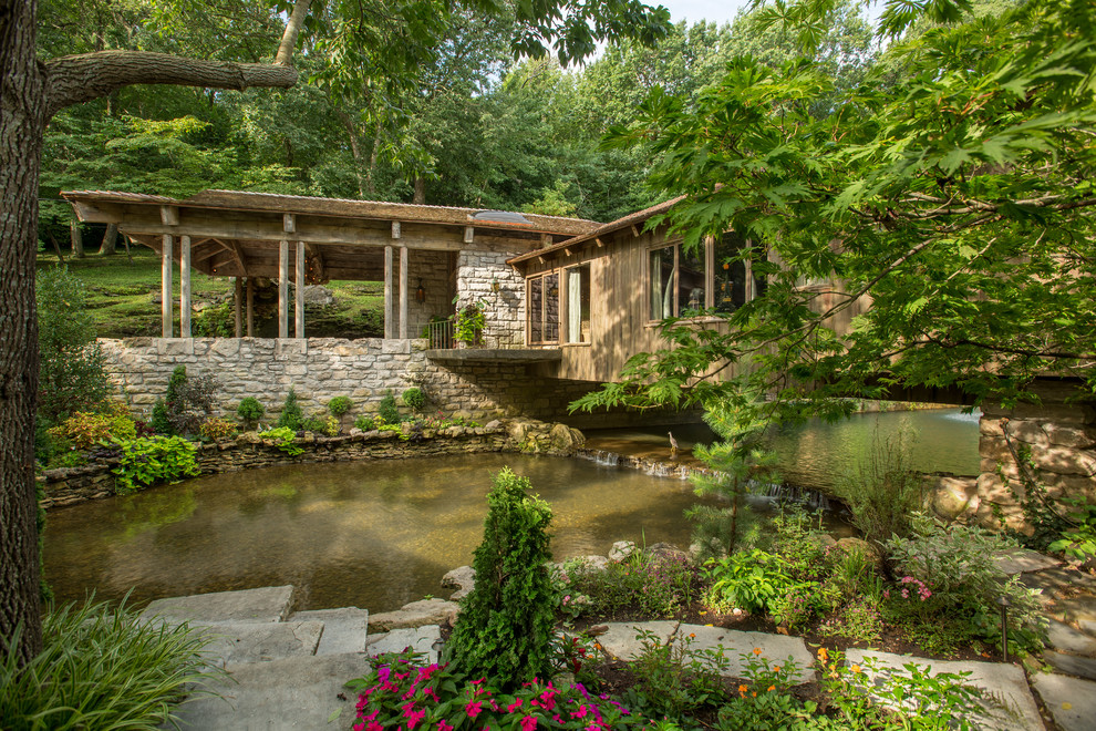 Diseño de jardín rústico en verano con jardín francés, fuente y adoquines de piedra natural