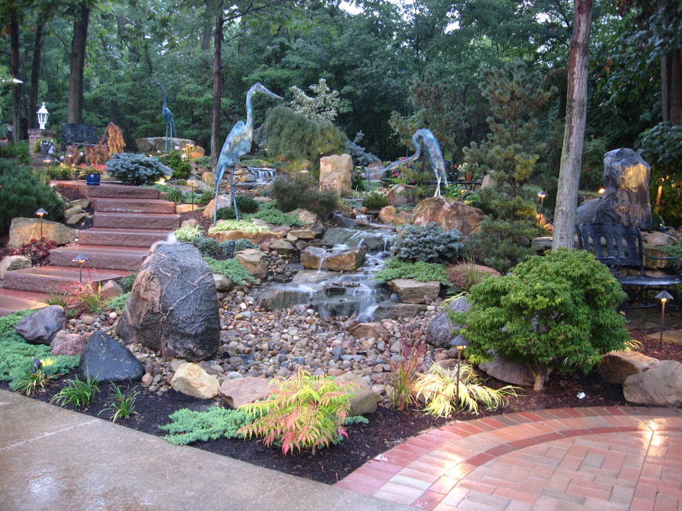 Medium sized traditional back full sun garden in Cleveland with a water feature and brick paving.