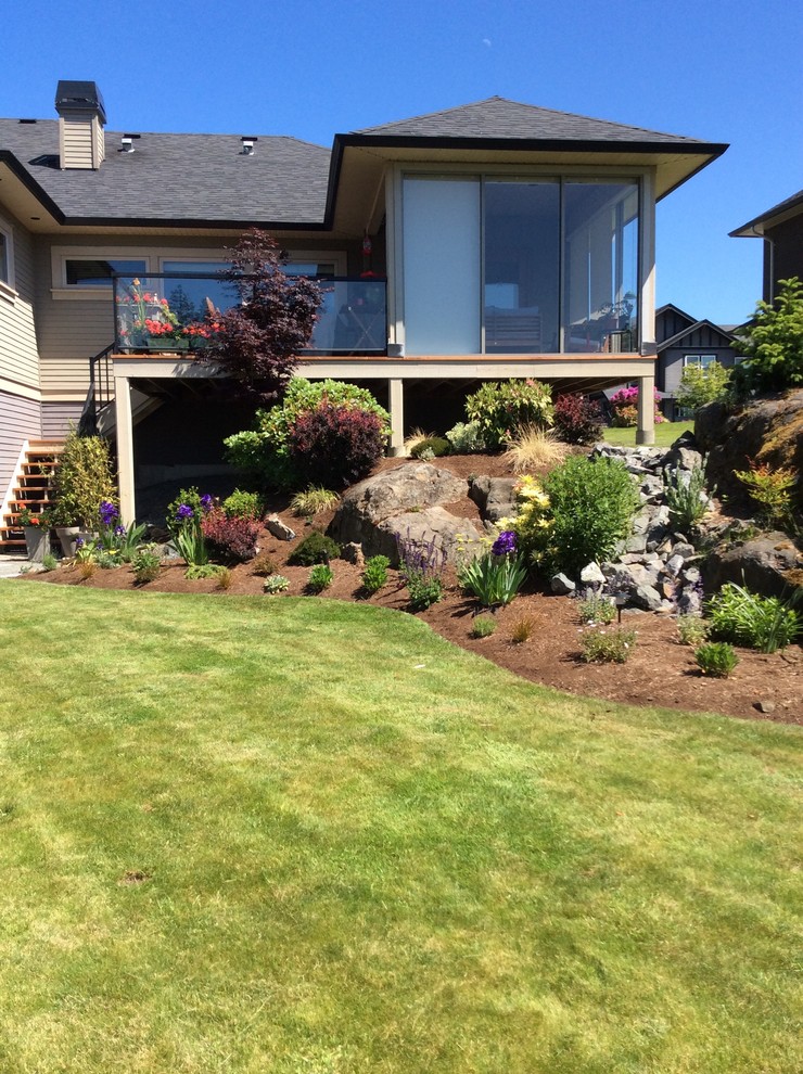 This is an example of a mid-sized contemporary full sun backyard gravel landscaping in Vancouver.