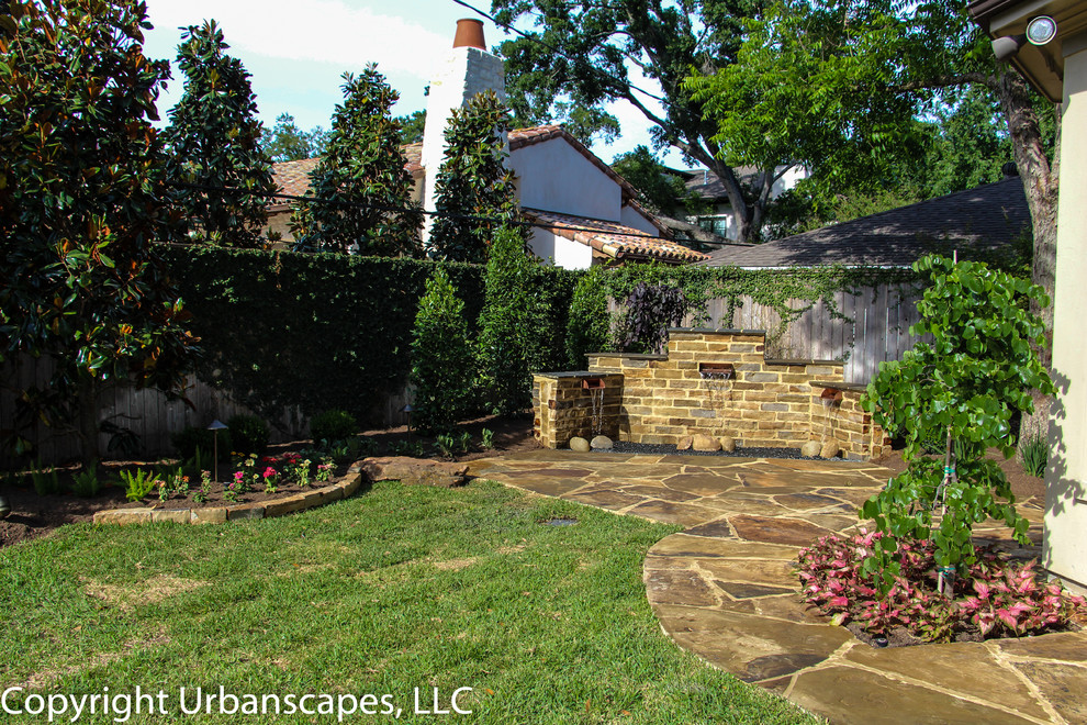Diseño de jardín clásico en verano en patio trasero con exposición total al sol y adoquines de piedra natural
