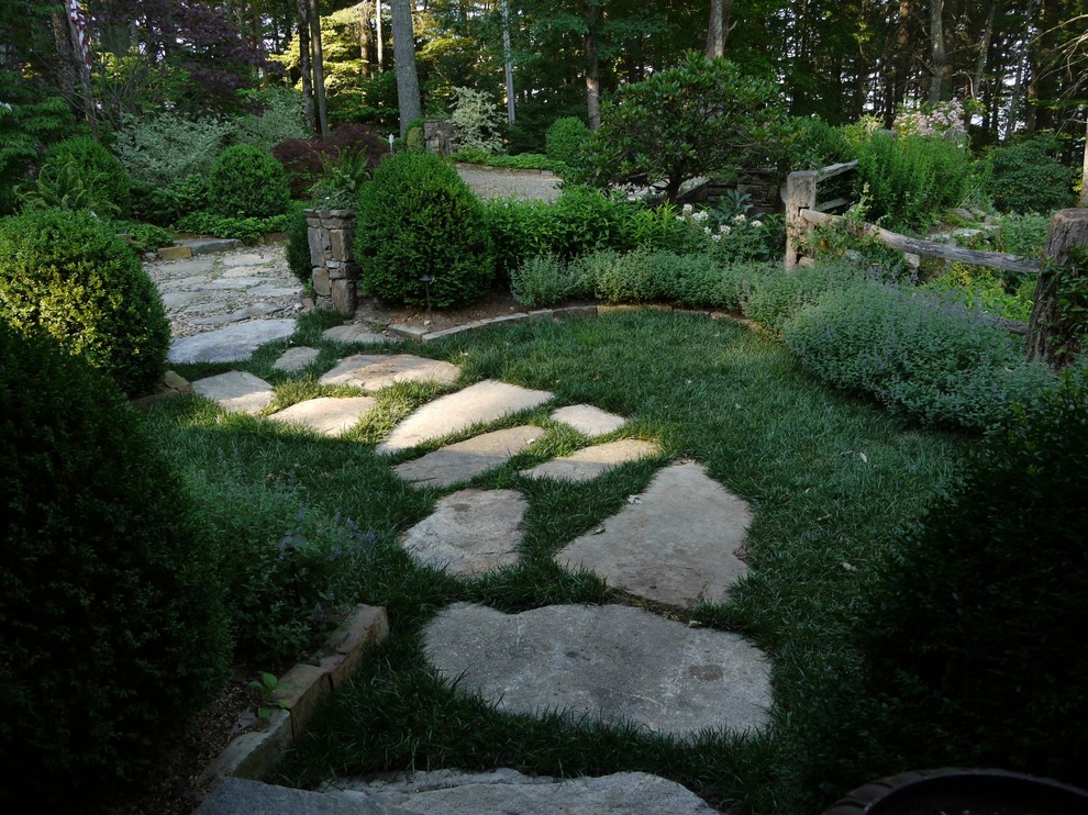 Réalisation d'un aménagement d'entrée ou allée de jardin avec une pente, une colline ou un talus et des pavés en pierre naturelle.