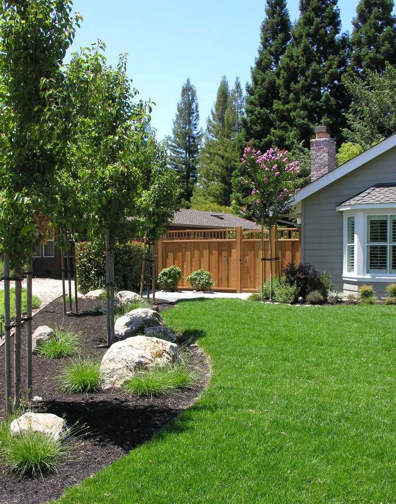 Foto di un giardino classico esposto in pieno sole di medie dimensioni e davanti casa in estate con un muro di contenimento e pavimentazioni in pietra naturale