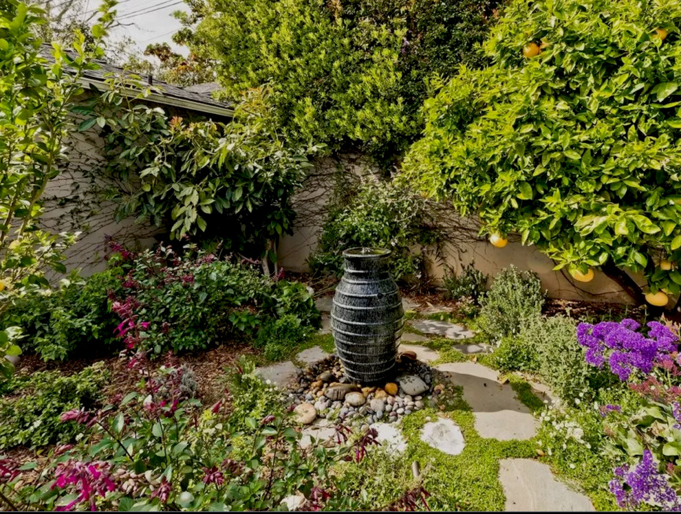 Mittelgroßer Klassischer Garten hinter dem Haus mit Wasserspiel, direkter Sonneneinstrahlung und Natursteinplatten in Los Angeles