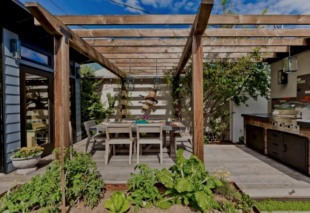 Cette photo montre un jardin arrière chic de taille moyenne avec une exposition ensoleillée et une terrasse en bois.
