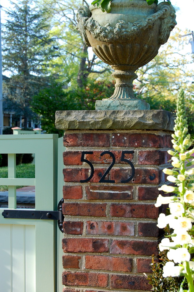 Immagine di un grande giardino american style esposto a mezz'ombra davanti casa in primavera con un ingresso o sentiero e pavimentazioni in mattoni