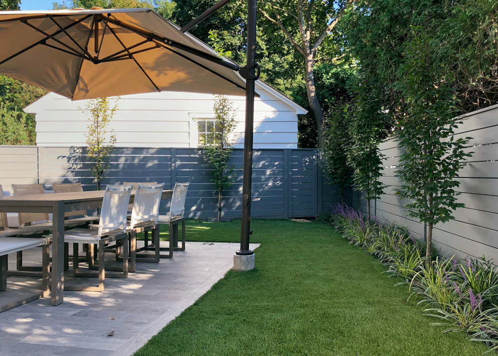 Immagine di un piccolo privacy in giardino minimal esposto a mezz'ombra dietro casa con pavimentazioni in pietra naturale