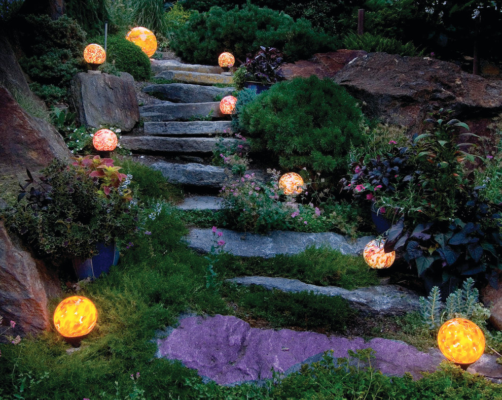Cette image montre un grand jardin arrière chalet l'été avec une exposition ensoleillée et des pavés en pierre naturelle.