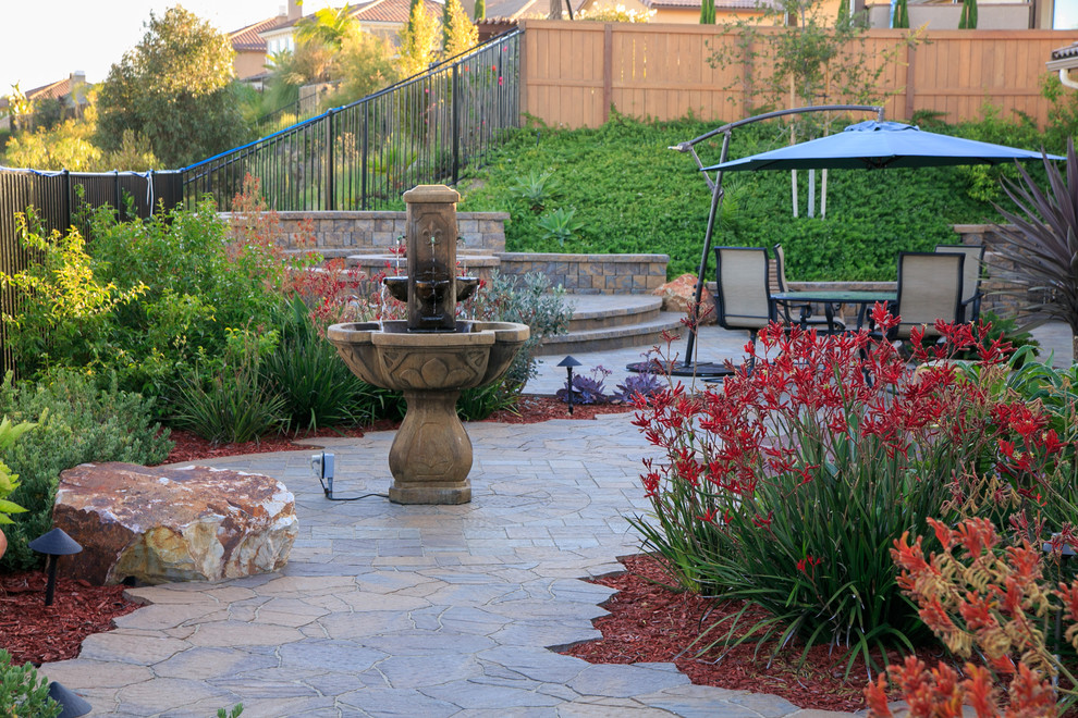 Foto de jardín de estilo americano grande en patio trasero con jardín francés, fuente y adoquines de hormigón