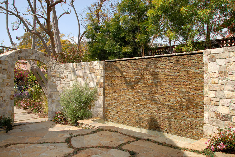 Diseño de jardín mediterráneo en patio con fuente y adoquines de piedra natural