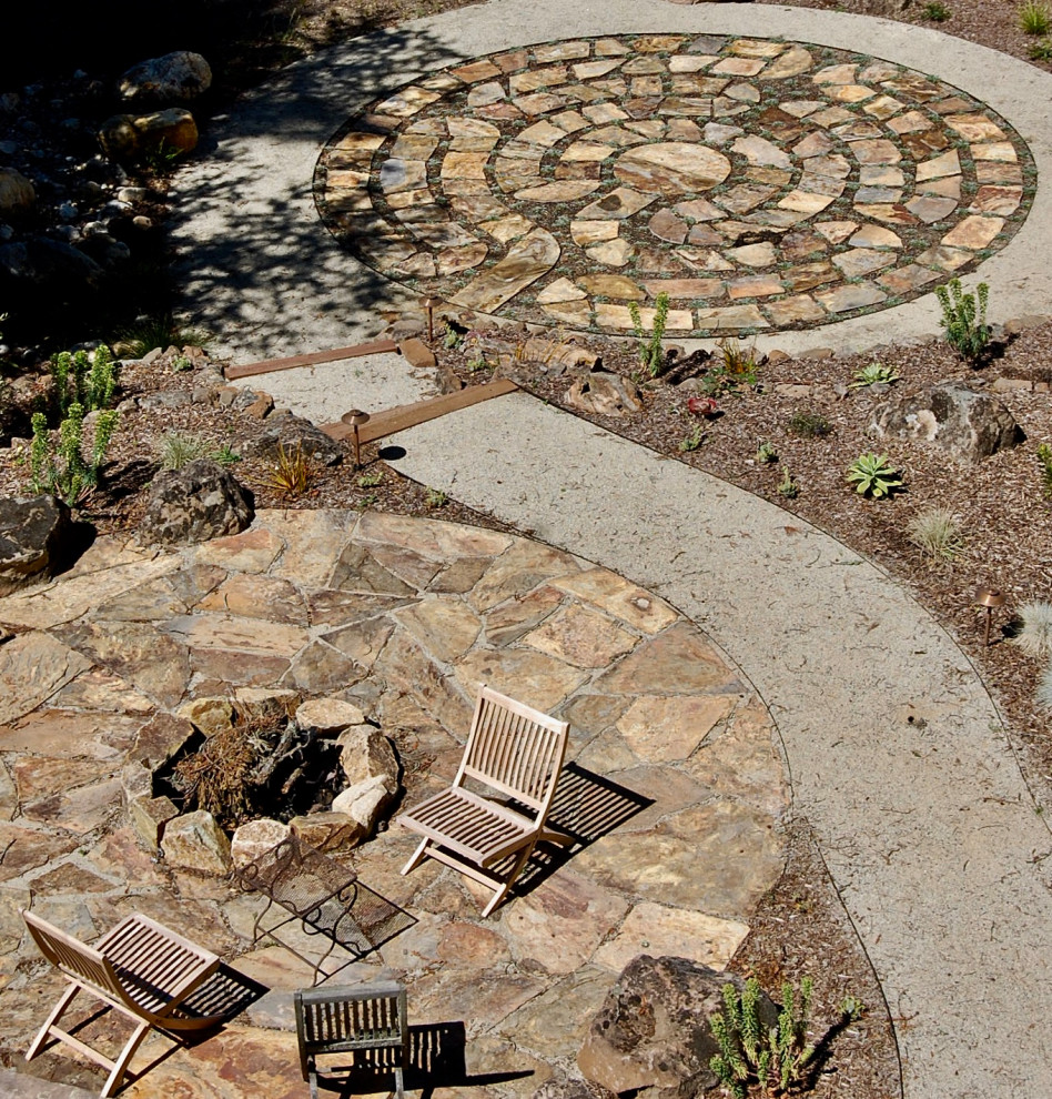 На фото: большой солнечный, весенний засухоустойчивый сад на заднем дворе в современном стиле с местом для костра, хорошей освещенностью и покрытием из каменной брусчатки