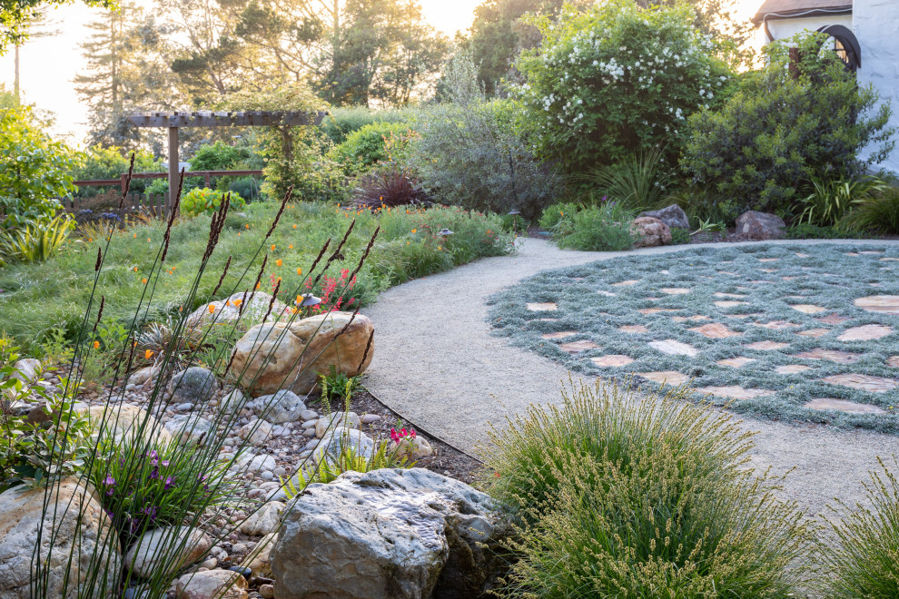 This is an example of a large contemporary back xeriscape full sun garden for spring in San Francisco with a fire feature and natural stone paving.