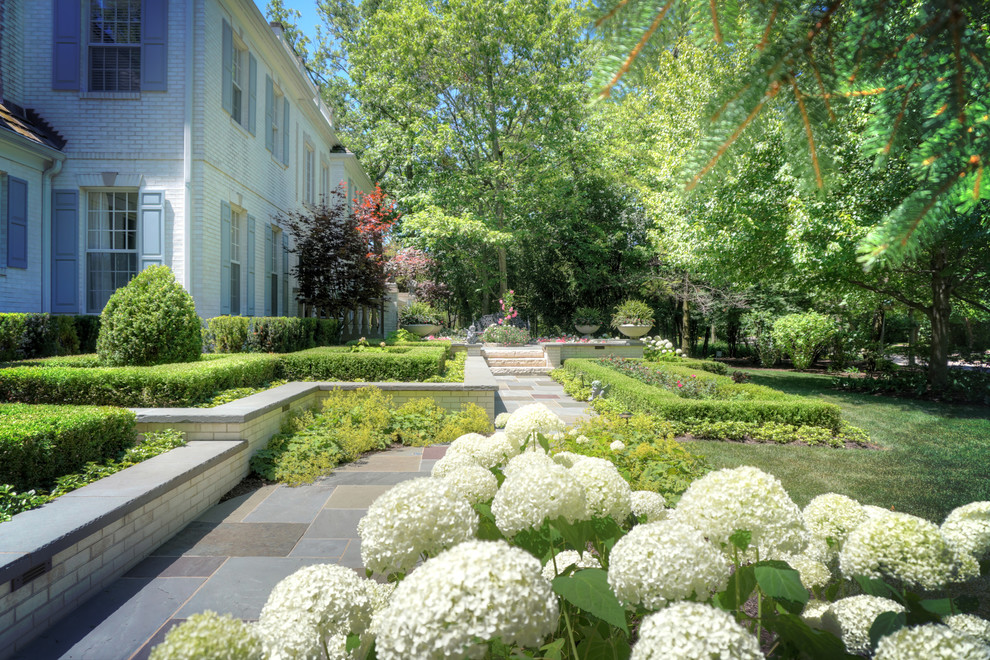 Cette photo montre un grand jardin avant chic l'hiver avec une exposition ensoleillée et des pavés en pierre naturelle.