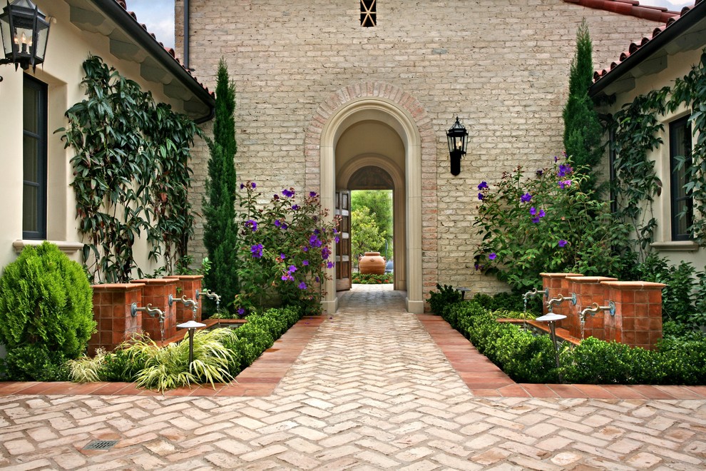 This is an example of a mediterranean courtyard garden in Los Angeles with a water feature.