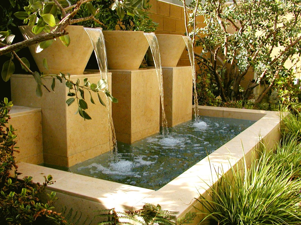 Bild på en medelhavsstil trädgård, med en fontän