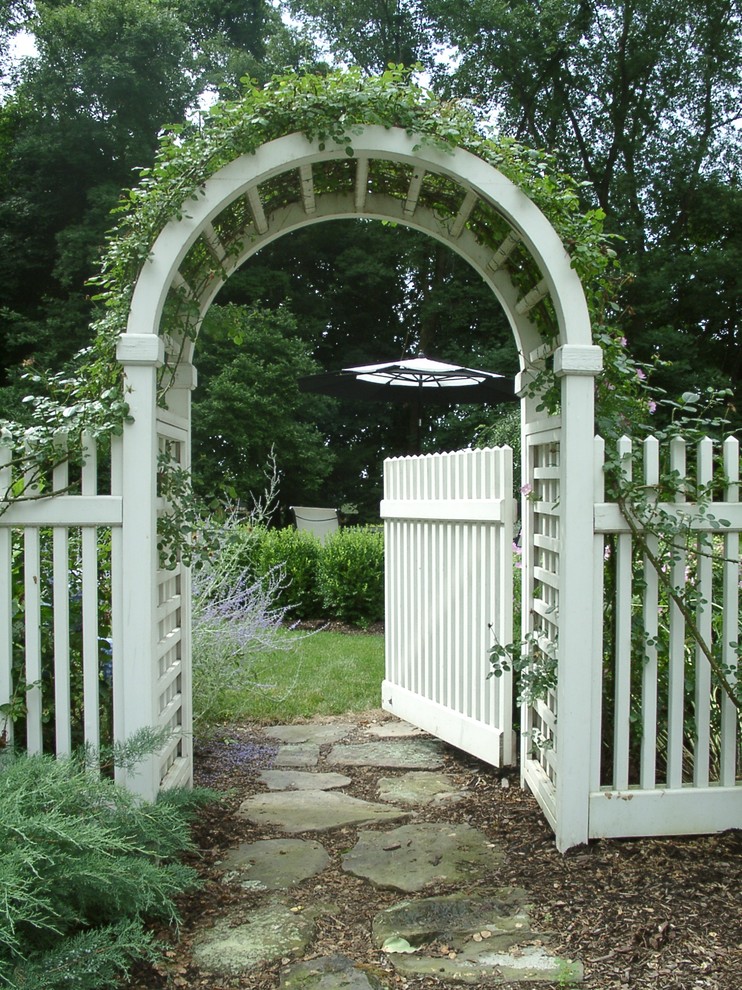 Klassischer Garten im Sommer, hinter dem Haus mit Auffahrt, Natursteinplatten und direkter Sonneneinstrahlung in New York