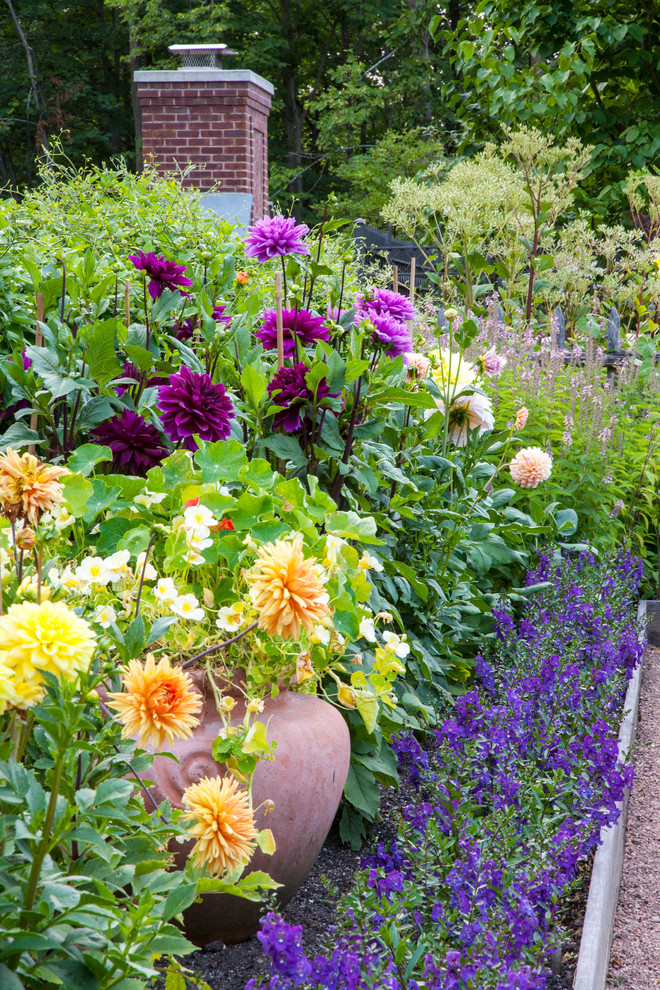 Imagen de jardín clásico grande en verano en patio trasero con jardín francés, jardín de macetas, exposición total al sol y gravilla