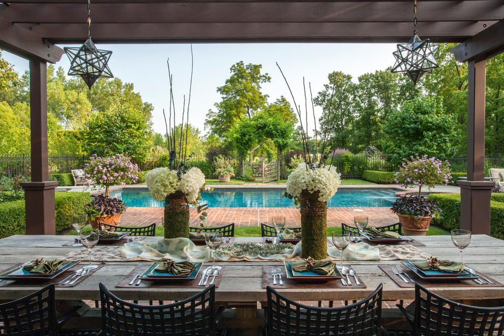 Diseño de jardín clásico grande en verano en patio trasero con jardín francés, fuente, exposición total al sol y adoquines de ladrillo
